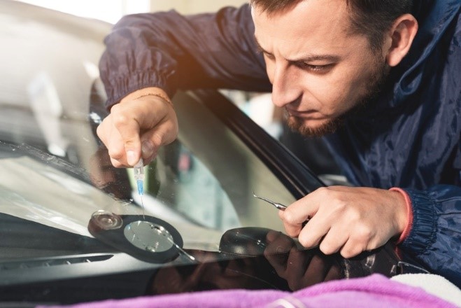 A person fixing a windshield